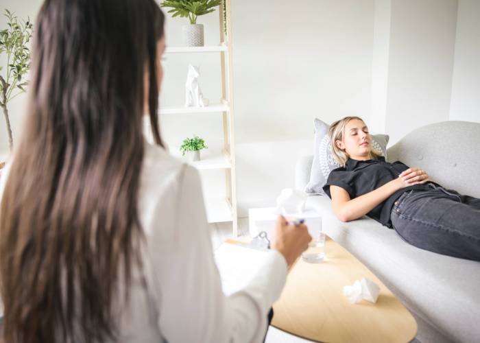 A,Psychotherapist,Supporting,Depressed,Teenage,Girl,On,Couch,During,Appointment Frau liegt auf Liege bei Hypnosetherapeutin